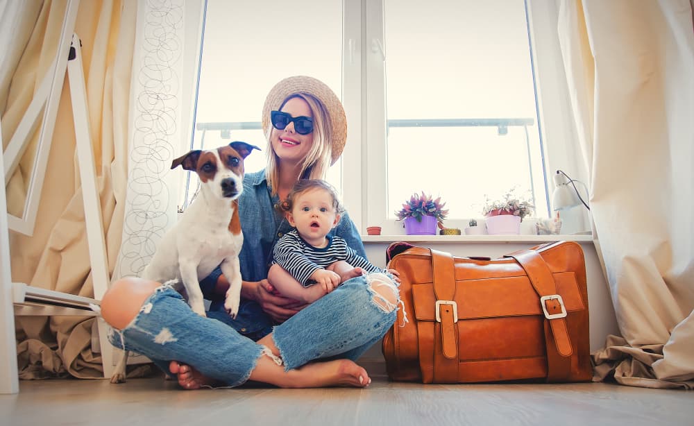 Woman packing for vacation with dog and baby
